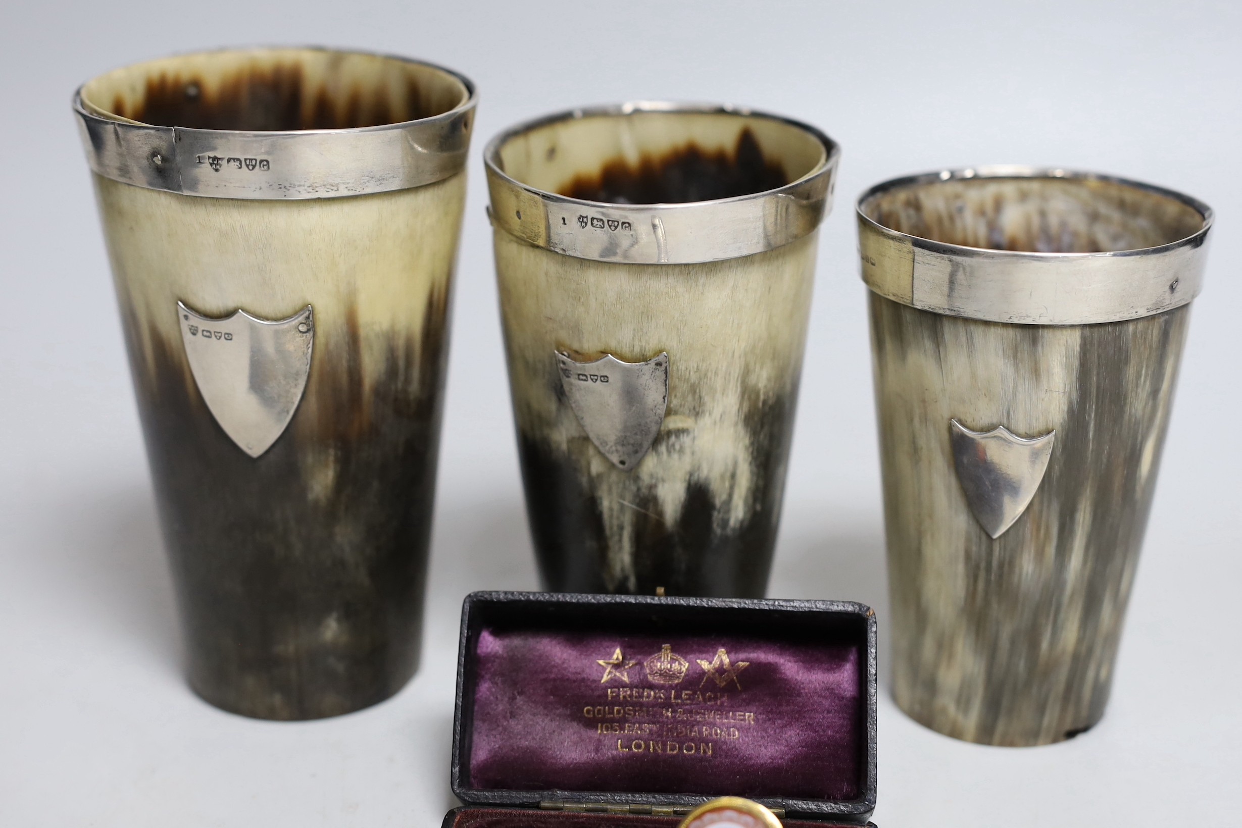 Two Edwardian silver mounted horn beakers, Haseler Brothers, Chester, 1903, largest 12.3cm, a similar Victorian beaker, a sardonyx mounted stick pin, nine assorted penknives/nail implements and an Edwardian silver and en